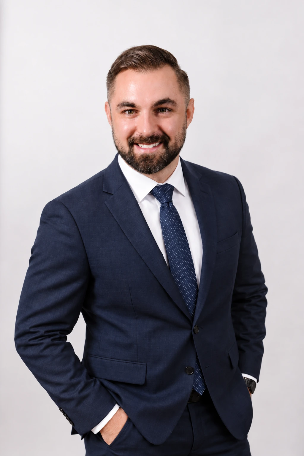 Kevin DeMara wearing a navy suit against a light studio background.